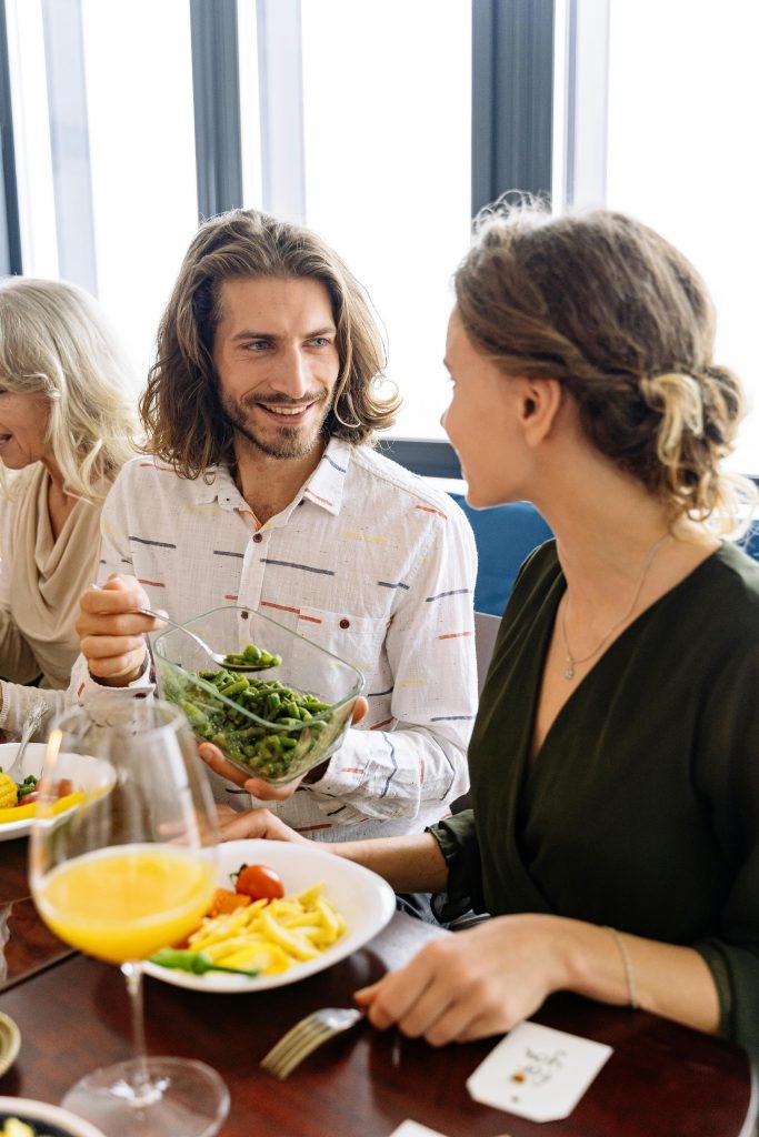 A group of adults enjoying brunch indoors, sharing food and smiles. Vibrant and lively atmosphere.