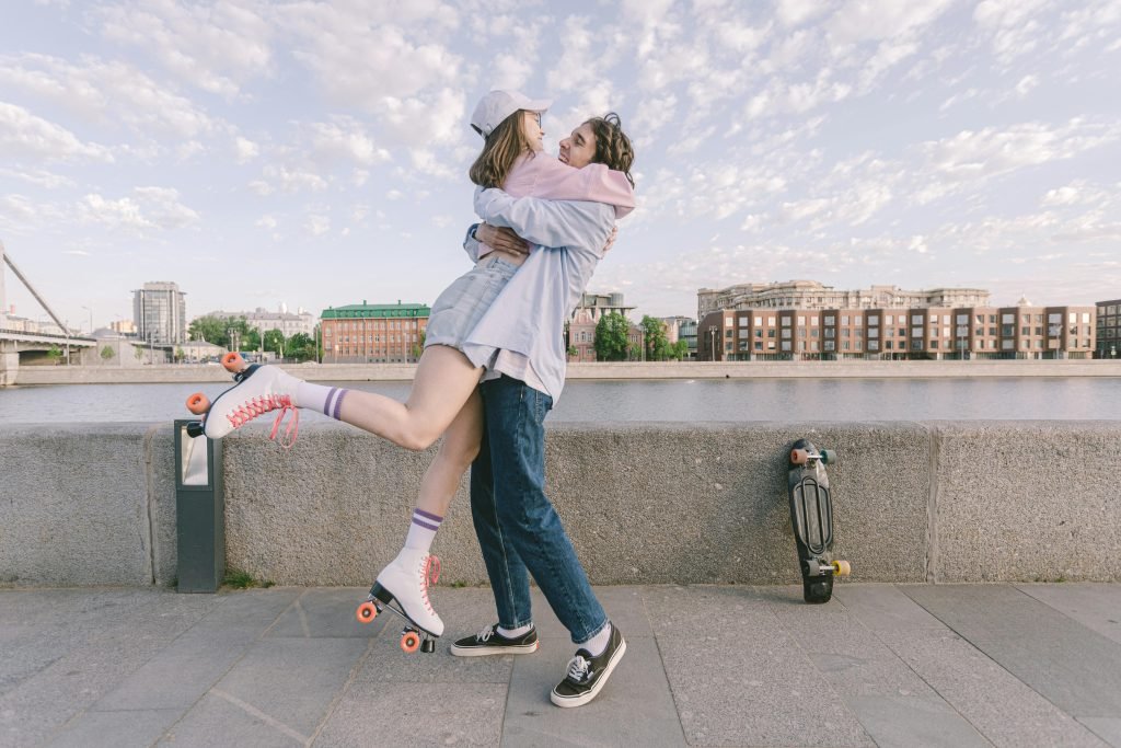 Joyful couple hugging on a riverside with roller skates, embodying romance and togetherness.